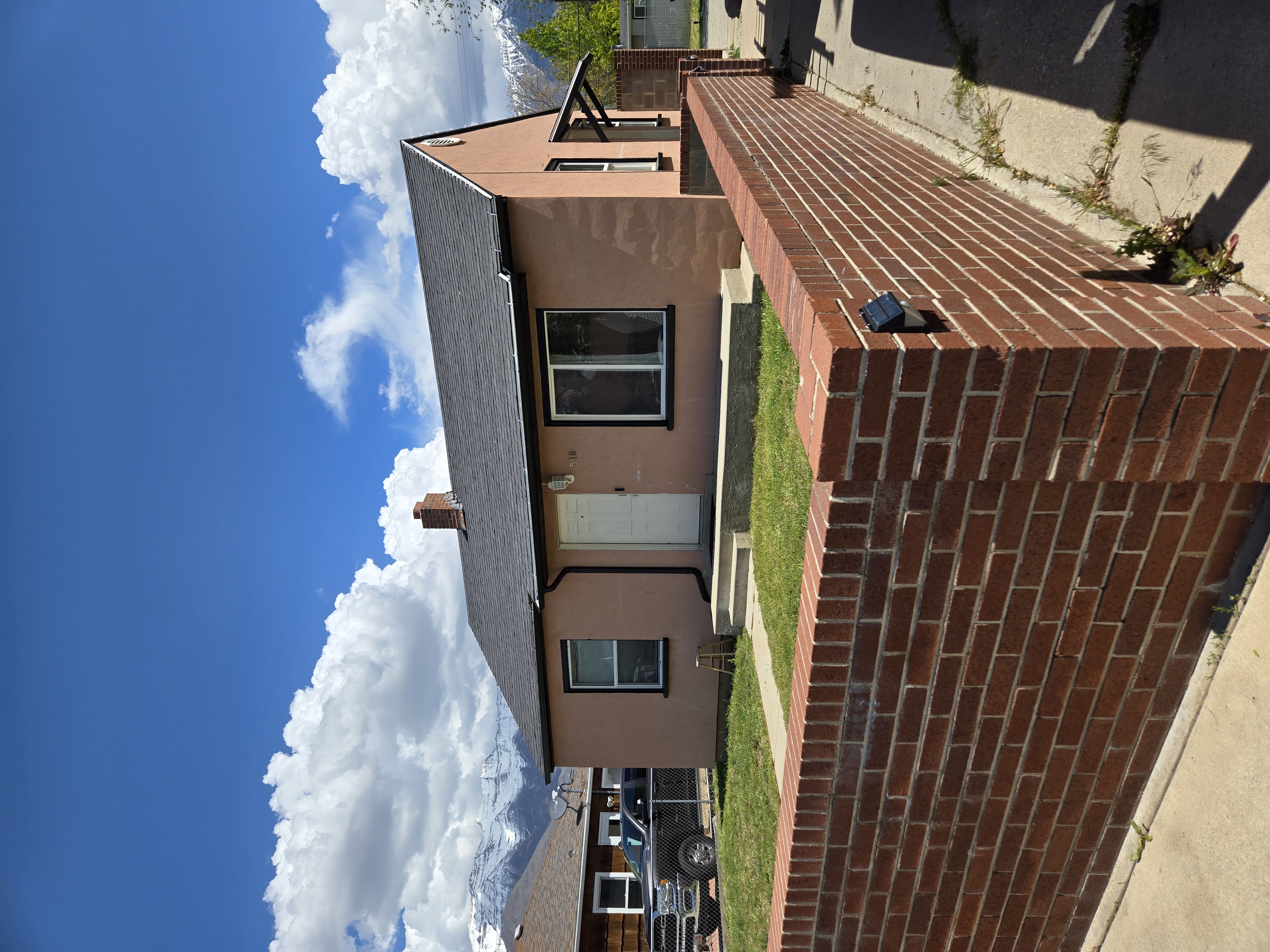 Black roof on a stucco home with mountains behind