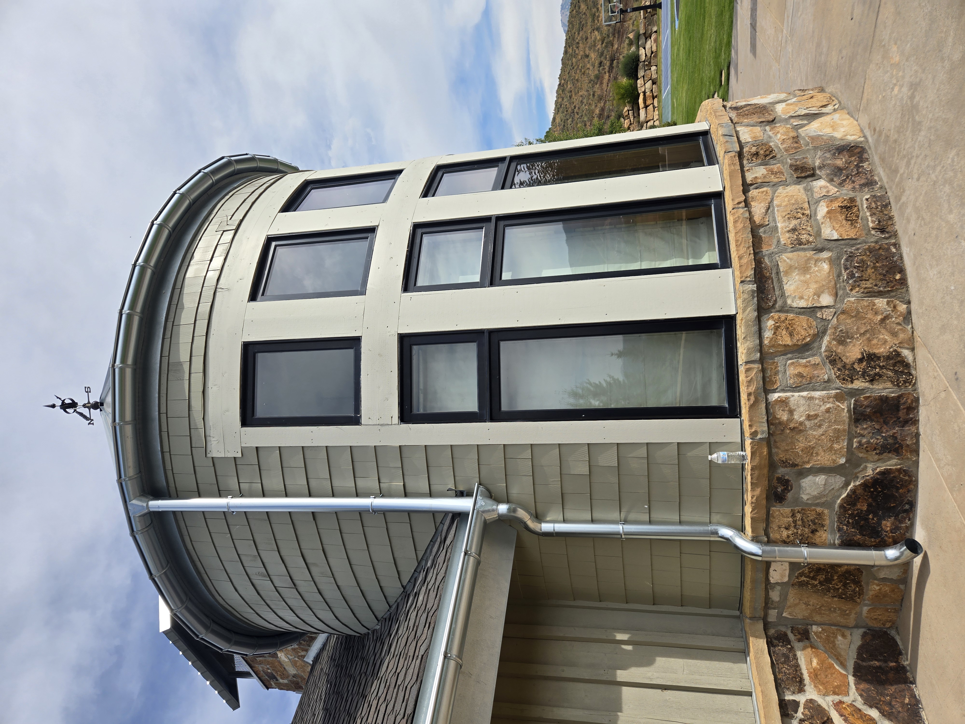 Shake siding on a turret with a stone foundation